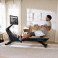 Man using black NordicTrack rowing machine with digital screen in home gym setting