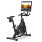 Black NordicTrack stationary bike with curved handlebars, seat, and pedals, topped with mounted tablet display showing cyclin