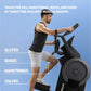 Man using black step climber machine against blue background, wearing black tank top and white shorts