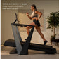 Woman running on incline treadmill wearing cream sports bra and black shorts, demonstrating adjustable incline feature in hom
