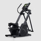 Black elliptical machine with digital display console and curved handlebars on white background