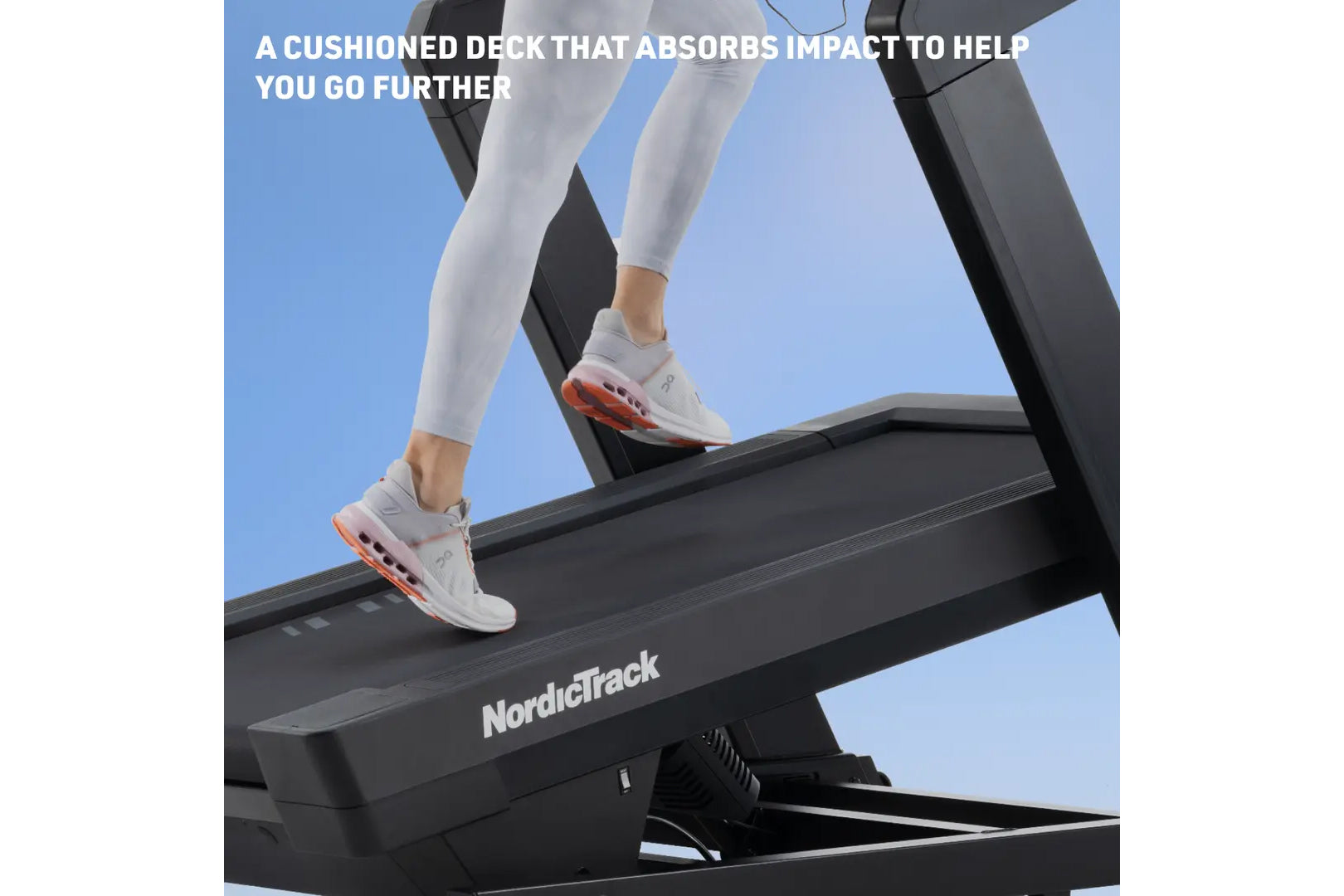 Runner wearing white sneakers with orange accents on NordicTrack treadmill with cushioned black deck