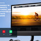 Black 24-inch HD monitor displaying iFIT Pro Membership content with cyclist on road, showing Movies, TV, and Music app icons