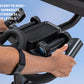Black stationary exercise bike with digital display and resistance controls, held by person's hands against blue sky backgrou