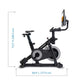 Black upright stationary exercise bike with gray flywheel and digital display console mounted on handlebar, shown with dimens