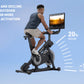 Man using black stationary exercise bike with screen displaying outdoor scenery, demonstrating incline and decline resistance