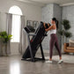 Black ProForm Carbon TLS treadmill with red accents, woman in white tank top and burgundy leggings running on treadmill in mo