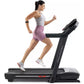 Woman running on black ProForm Carbon TLS treadmill wearing gray tank top, mauve shorts, and white sneakers with fitness trac