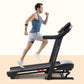 Man running on black ProForm Carbon TLS treadmill wearing blue tank top and white shorts, shown in profile on beige backgroun