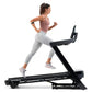 Woman running on NordicTrack black treadmill wearing mauve tank top and gray leggings, white sneakers, on white background