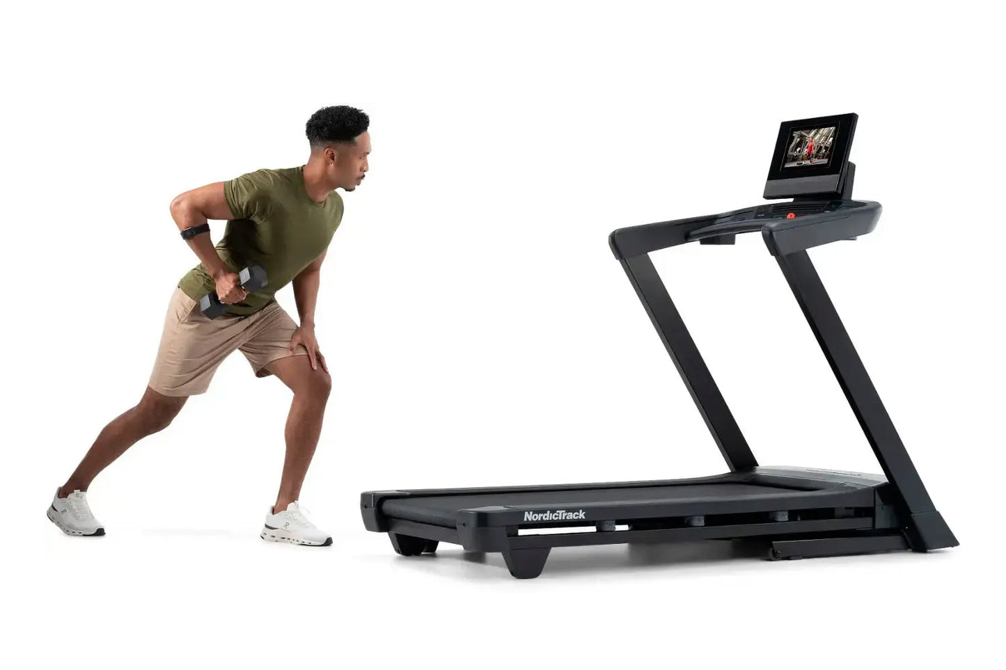 Man in olive green shirt and tan shorts performing interval training on NordicTrack black treadmill with digital display