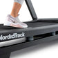 Person wearing white and pink sneaker running on NordicTrack black treadmill with handrail