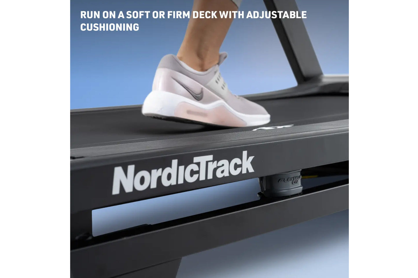 White and gray running shoe with cushioned sole worn by model on NordicTrack treadmill deck