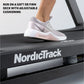 White and gray running shoe with cushioning worn by runner on NordicTrack treadmill deck