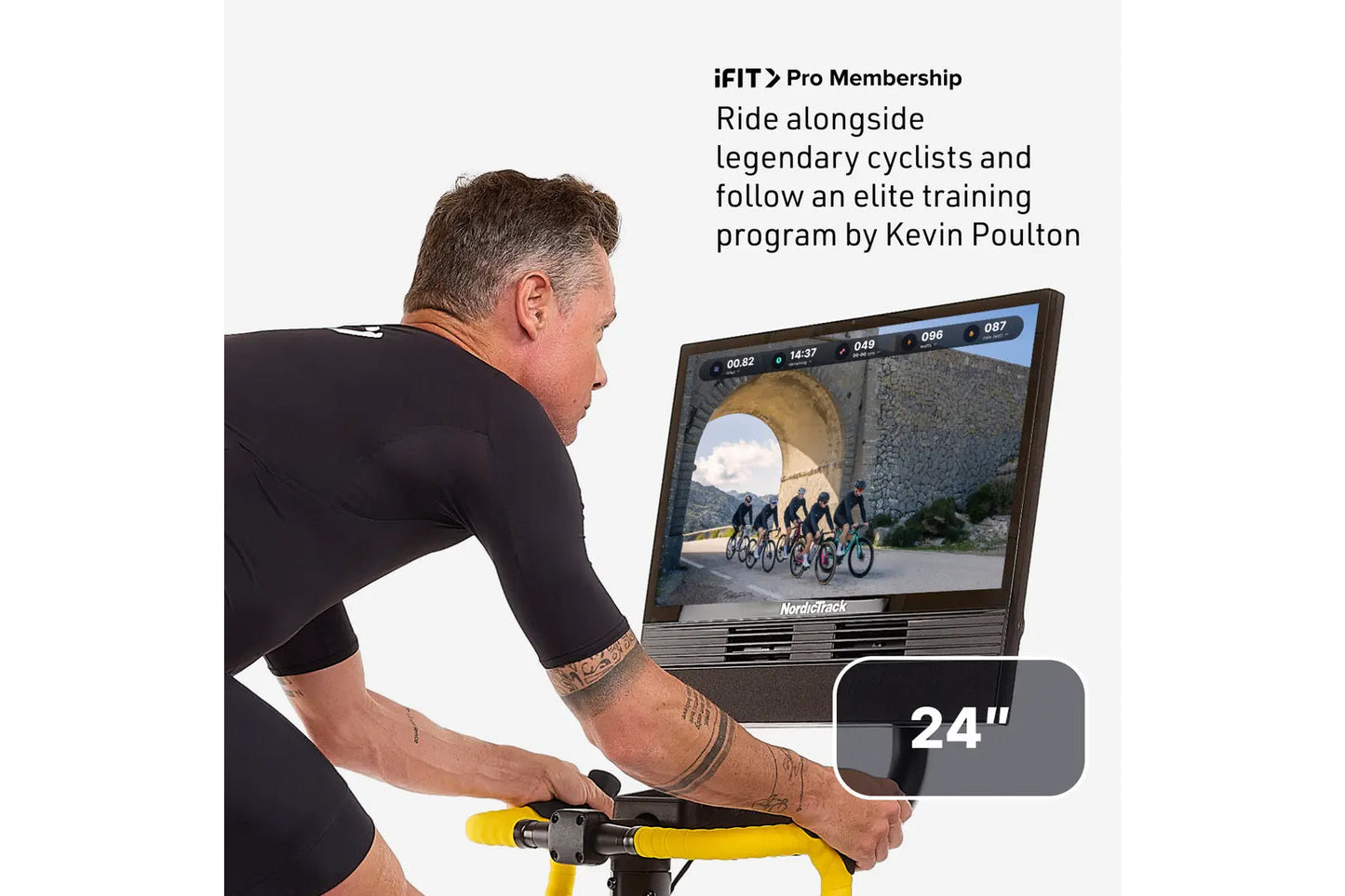 Man on stationary bike with yellow handlebars riding virtual cycling class on NordicTrack 24-inch screen displaying elite tra