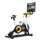 NordicTrack Tour de France indoor stationary bike with white frame, yellow and black flywheel, yellow handlebars, and attache