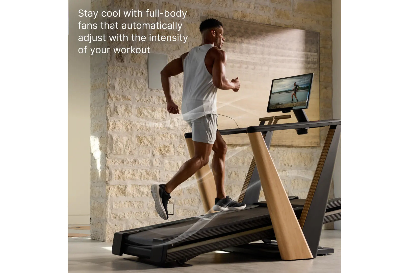 Man running on NordicTrack treadmill with wood and black frame in modern loft space with brick wall