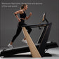 Woman running on black and natural wood incline treadmill with digital display, wearing black sports bra and leggings with wh
