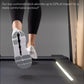 Person in black leggings and white running shoes on cushioned treadmill deck, shown from below during workout