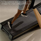 Person jogging on black treadmill with cushioned deck, wearing black and white sneakers and light blue shorts