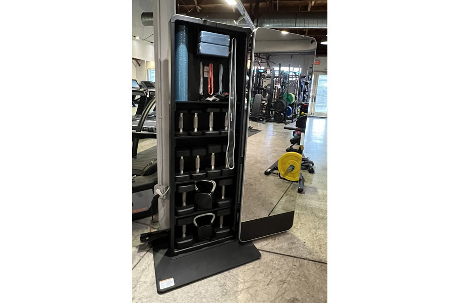 Black NordicTrack Vault home gym mirror with open door displaying stored weights, resistance bands, and workout accessories i
