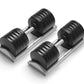 Pair of black adjustable dumbbells with silver handles on gray trapezoidal base, shown on white background