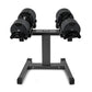 Pair of black adjustable dumbbells on stand with textured grip handles and weight plates, on white background