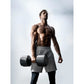 Shirtless man holding black adjustable dumbbells wearing gray shorts against white background