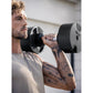 Man lifting black and gray adjustable dumbbell with weight dial, worn by model during exercise