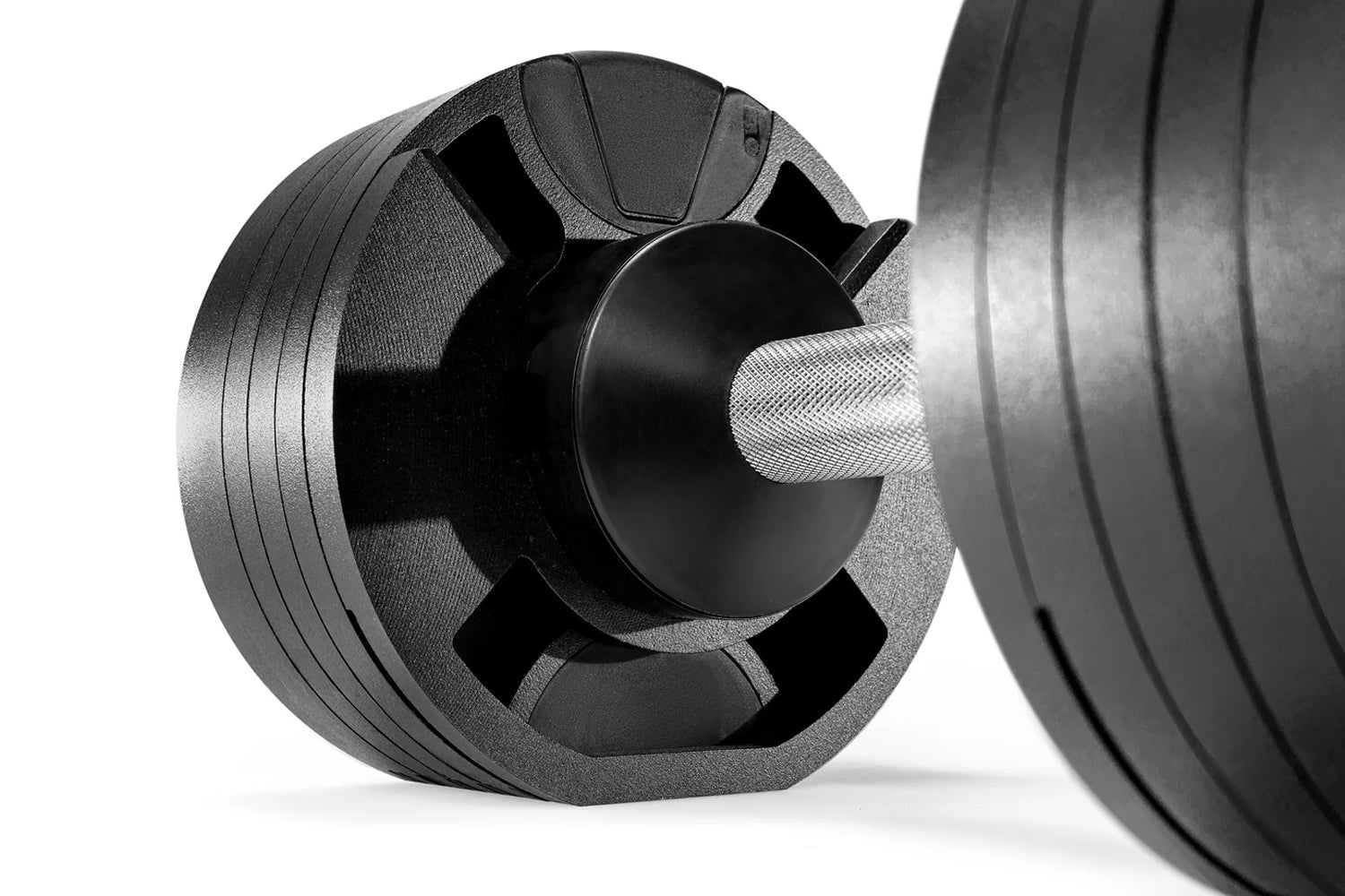 Pair of black and gray adjustable dumbbells with ribbed plates and textured grip handles on white background