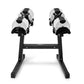 Pair of Nüobell adjustable dumbbells in white and black on black stand, flat lay on white background