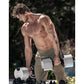 Man with curly hair and tattoos lifting white and black NÜOBELL adjustable dumbbells outdoors, wearing olive shorts