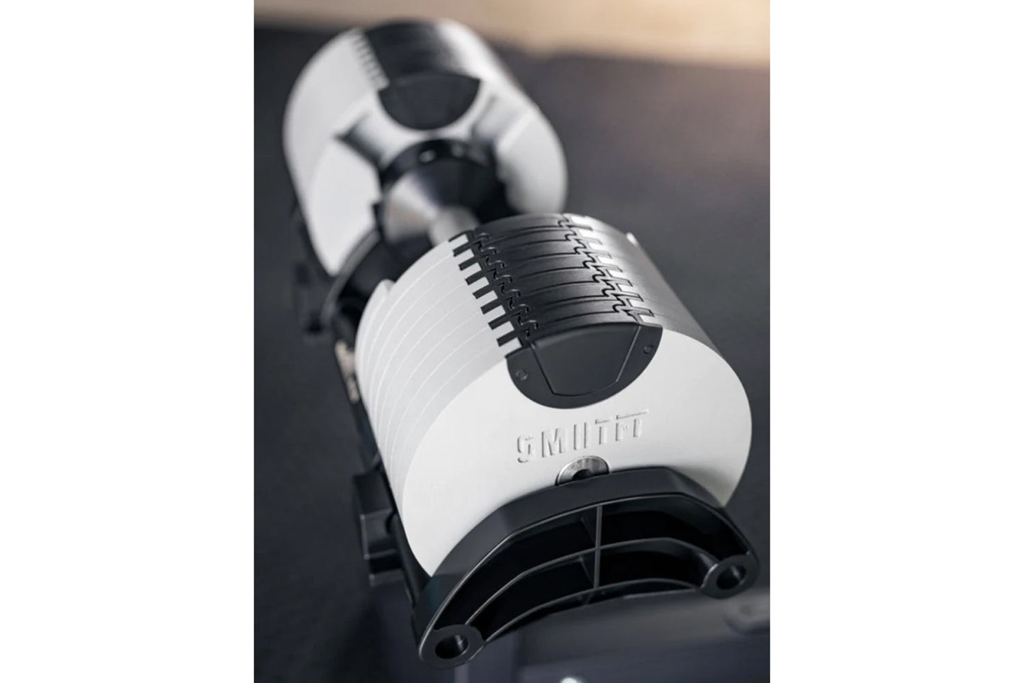 NÜOBELL 80lb adjustable dumbbell in white and black with metal weight plates and adjustment mechanism, shown on dark surface