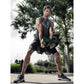 Man holding olive and black adjustable dumbbells in wide stance during outdoor workout session