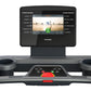 Octane OC100 treadmill with 10-inch black touchscreen console displaying fitness video, gray and black frame with dual cup ho