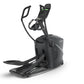 Black elliptical exercise machine with dual handles, wide foot pedals, and digital display console on white background