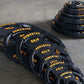 Powertec Olympic weight plates set in black rubber with yellow text markings, displayed in graduating sizes on concrete floor