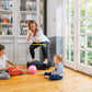 Woman in white top and black leggings with yellow waistband using black Power Plate vibration machine while two young childre