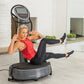 Woman in red tank top and black leggings using gray Power Plate My7 vibration platform trainer with digital display