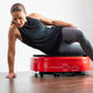 Woman in black tank top and gray leggings performing plank exercise on red Power Plate MOVE vibration trainer