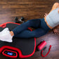 Woman doing abdominal exercise on red and black Power Plate vibration trainer with digital display, wearing gray crop top and