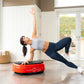 Woman in gray crop top and navy leggings performing a core exercise on a red Power Plate MOVE vibration trainer in a bright h