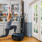 Woman performing a lunge with red dumbbells on black Power Plate My5 vibration trainer in home gym