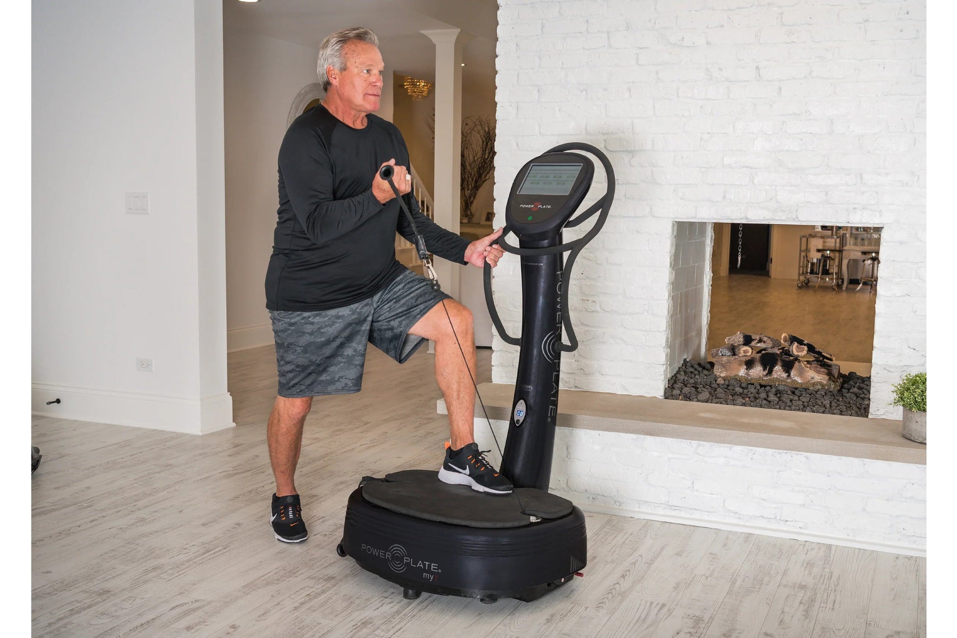 Man using black Power Plate My7 vibration plate trainer with digital display in home gym setting