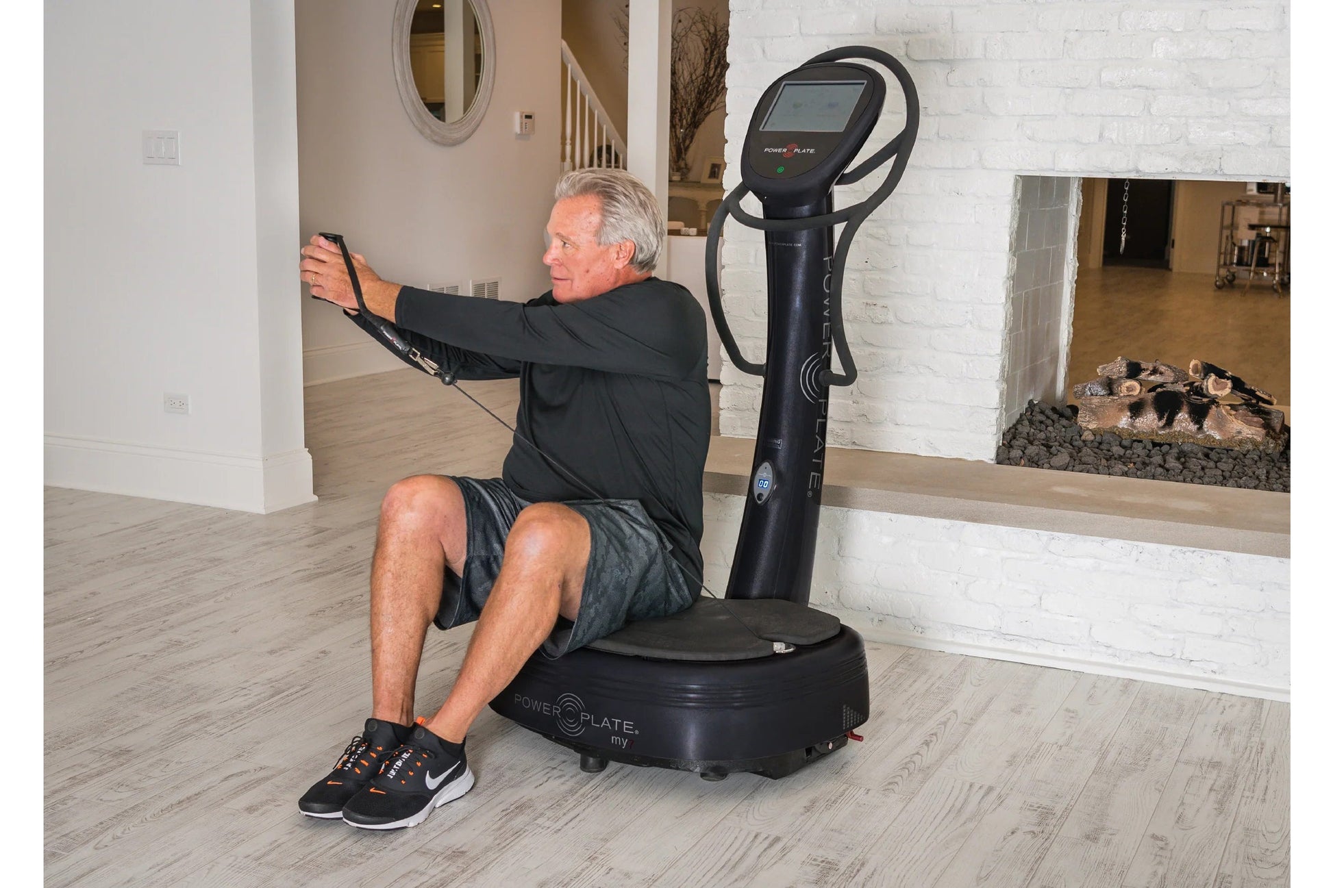 Black Power Plate My7 vibration plate trainer with digital display, man using device in home gym setting