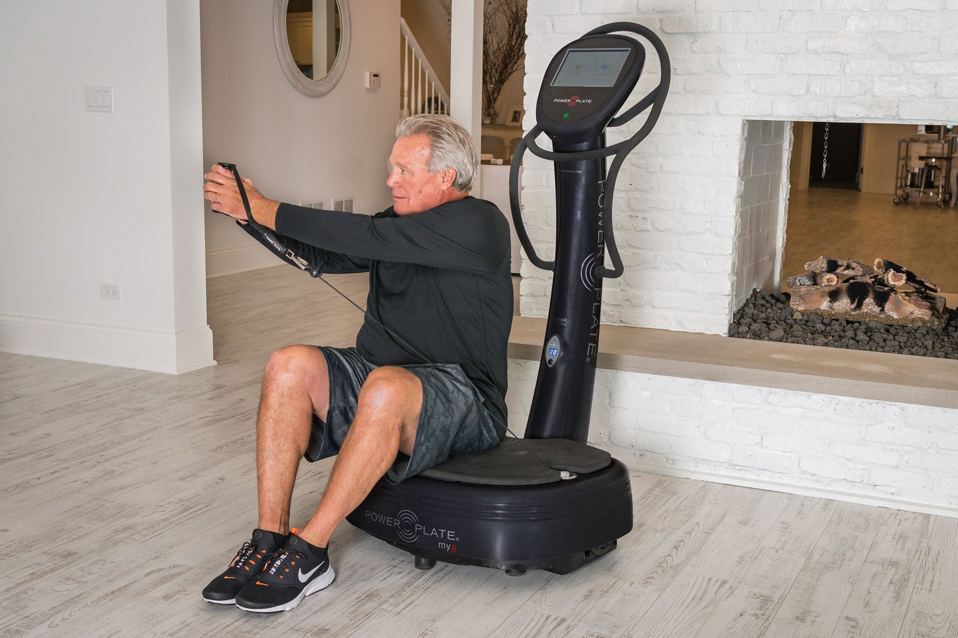 Man using black Power Plate My8 vibration plate trainer with digital display in home gym setting