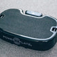 Black PowerPlate vibration machine with grey textured surface and control panel on top, flat lay view on grey background