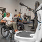 People using Power Plate vibration plate fitness equipment in accessible gym setting with wheelchair user in foreground