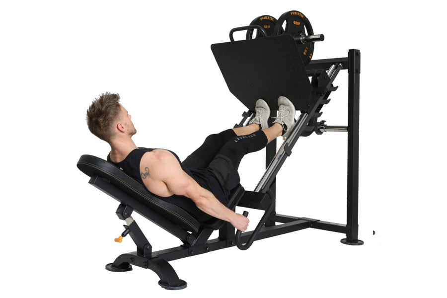Black leg press machine with weight plates, used by male model demonstrating exercise position on white background