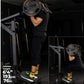 Person in black shirt and shorts performing seated calf raise on black Powertec leverage gym machine with orange-labeled weig